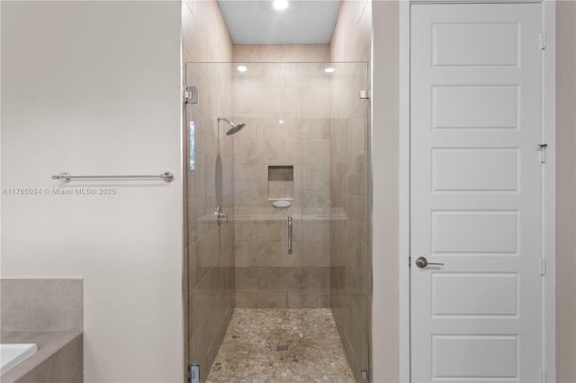 bathroom featuring a bathing tub and a shower stall