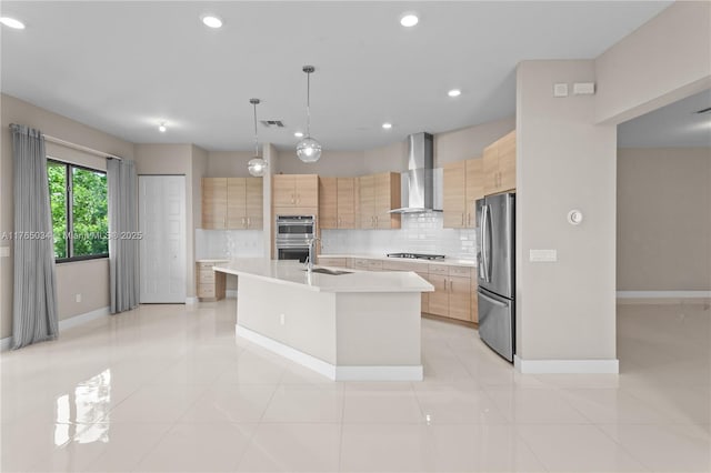 kitchen with wall chimney range hood, light countertops, a sink, light brown cabinets, and stainless steel appliances