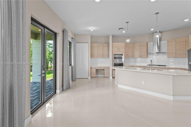 kitchen featuring wall chimney range hood, light brown cabinetry, modern cabinets, and light countertops
