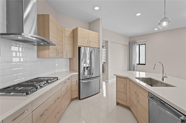 kitchen featuring a sink, wall chimney exhaust hood, light brown cabinetry, and stainless steel appliances