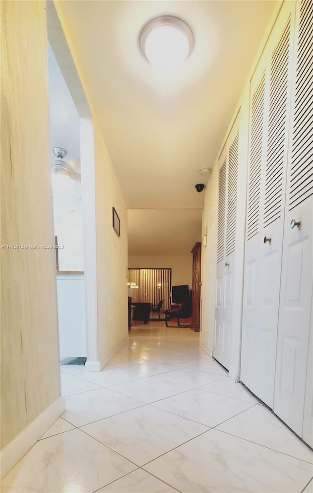 corridor with tile patterned floors and baseboards