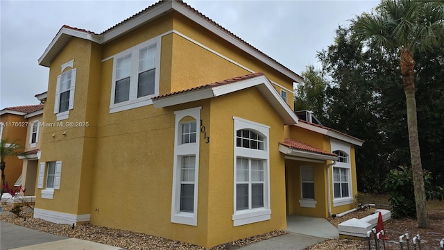 1013 Park Ridge Cir, Kissimmee, FL 34746 - view of side of home with a tiled roof and stucco siding