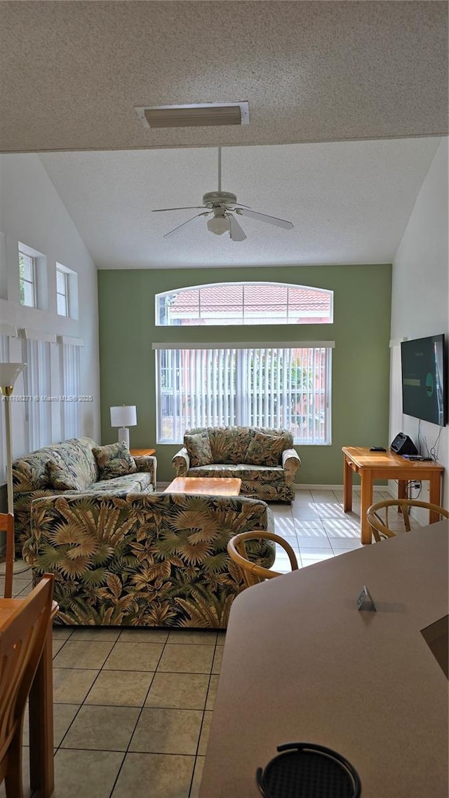 1013 Park Ridge Cir, Kissimmee, FL 34746 - living room featuring a textured ceiling, vaulted ceiling, light tile patterned floors, and ceiling fan