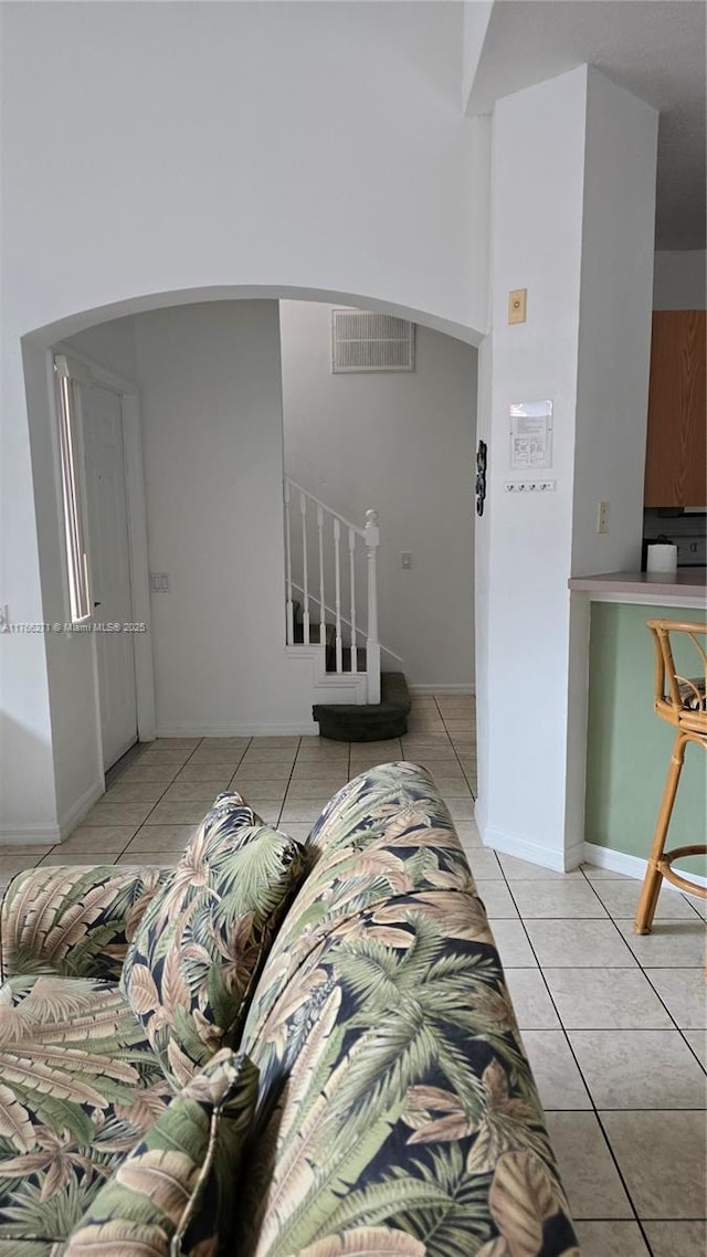 1013 Park Ridge Cir, Kissimmee, FL 34746 - interior space featuring stairway, light tile patterned floors, baseboards, visible vents, and arched walkways