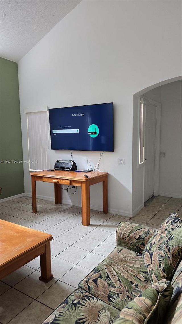 1013 Park Ridge Cir, Kissimmee, FL 34746 - interior space featuring light tile patterned flooring, a textured ceiling, baseboards, and vaulted ceiling