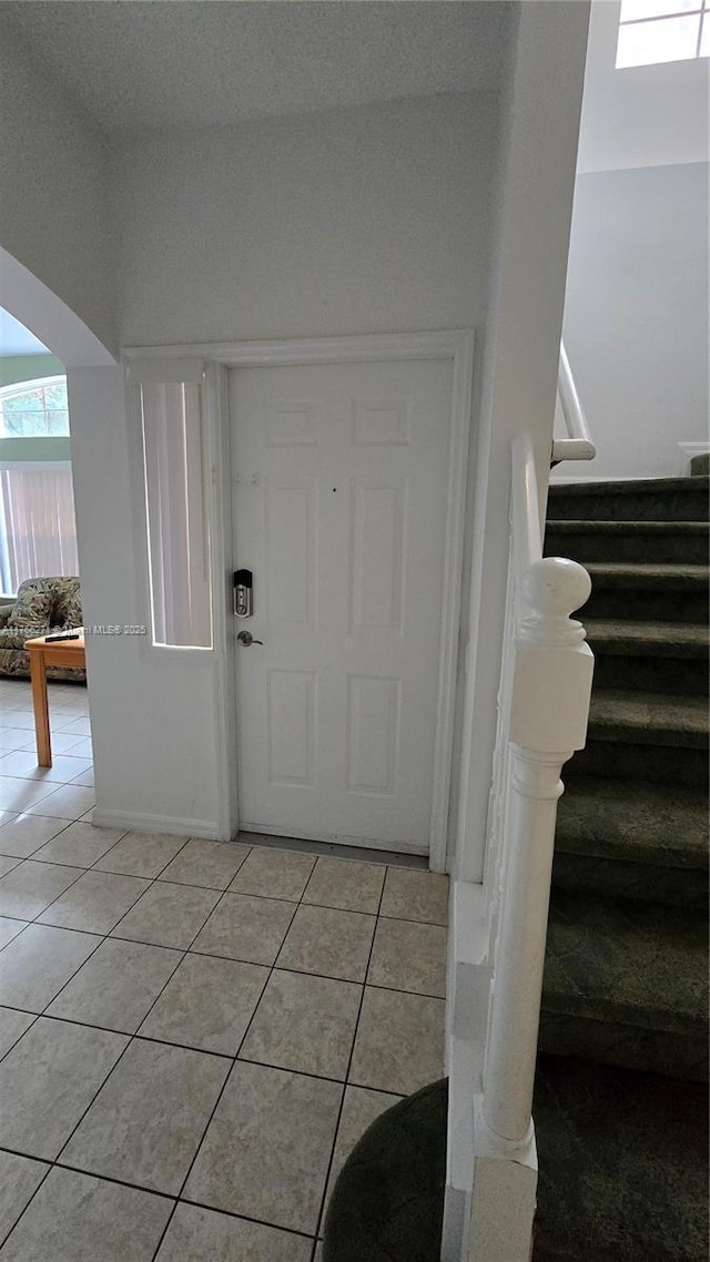 1013 Park Ridge Cir, Kissimmee, FL 34746 - foyer entrance with light tile patterned floors, stairway, and arched walkways