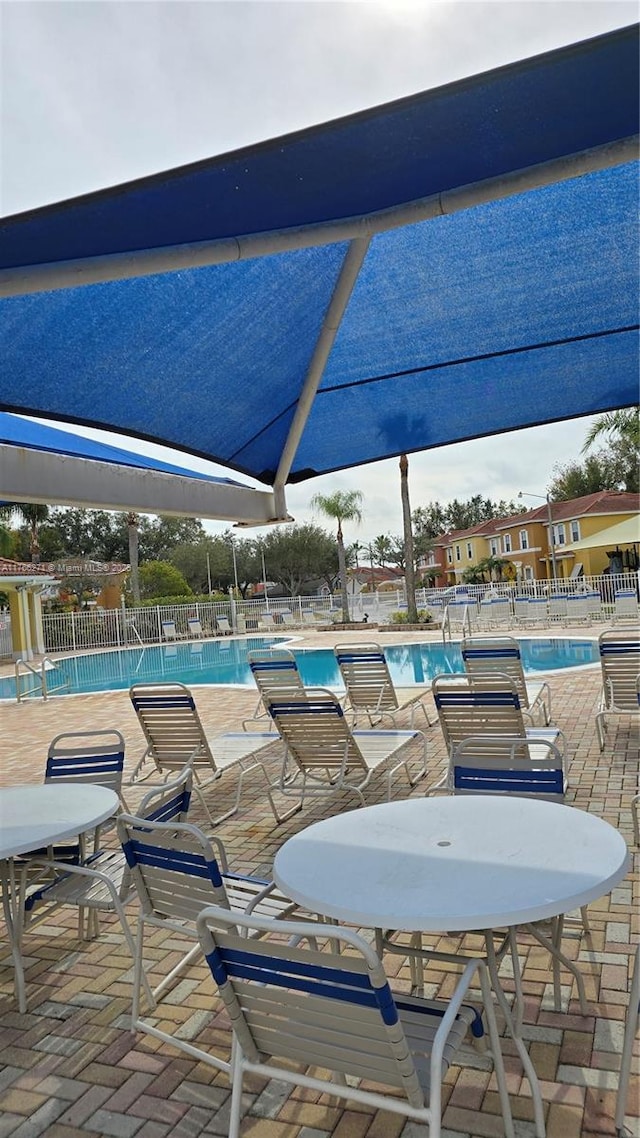 1013 Park Ridge Cir, Kissimmee, FL 34746 - view of patio featuring a community pool and fence