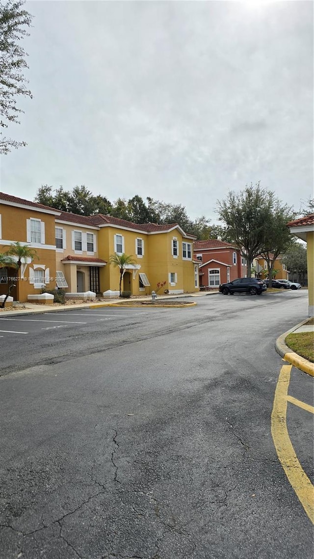 1013 Park Ridge Cir, Kissimmee, FL 34746 - view of property featuring stucco siding, a residential view, and uncovered parking
