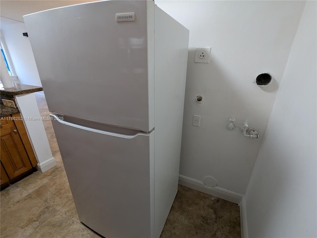 interior details featuring baseboards and freestanding refrigerator
