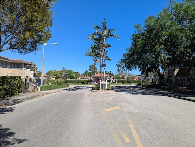 view of road with street lights, curbs, and sidewalks
