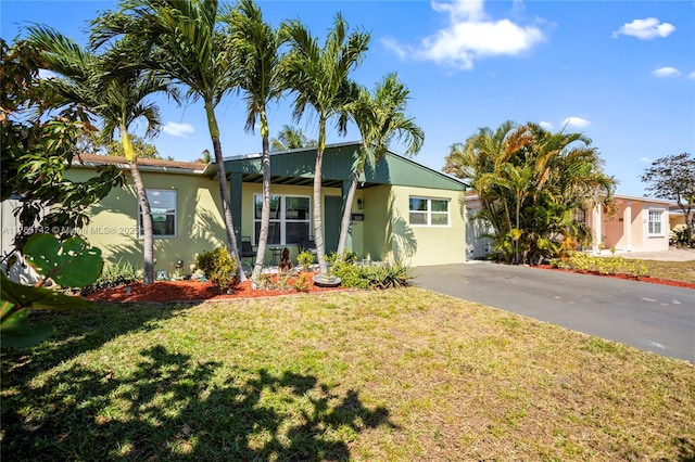 5233 NE 4th Ave, Oakland Park, FL 33334 - ranch-style home featuring a front yard and stucco siding