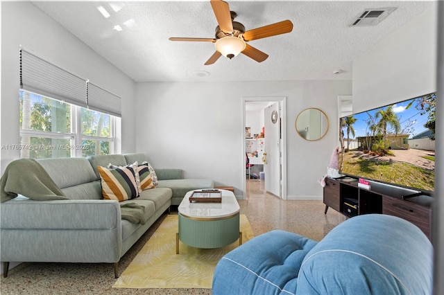 5233 NE 4th Ave, Oakland Park, FL 33334 - living room with baseboards, a textured ceiling, speckled floor, visible vents, and a ceiling fan