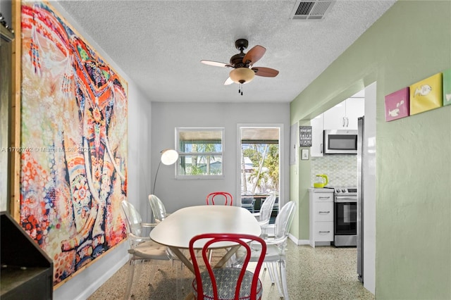 5233 NE 4th Ave, Oakland Park, FL 33334 - dining room with a textured ceiling, light speckled floor, baseboards, visible vents, and ceiling fan