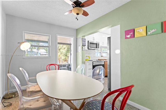 5233 NE 4th Ave, Oakland Park, FL 33334 - dining space with baseboards, a textured ceiling, and a ceiling fan