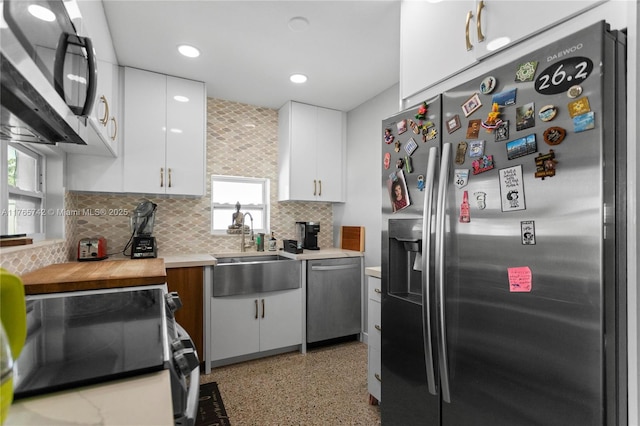 5233 NE 4th Ave, Oakland Park, FL 33334 - kitchen with white cabinetry, light countertops, tasteful backsplash, a sink, and appliances with stainless steel finishes