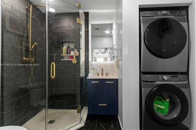 5233 NE 4th Ave, Oakland Park, FL 33334 - bathroom with decorative backsplash, stacked washer and clothes dryer, marble finish floor, a marble finish shower, and vanity