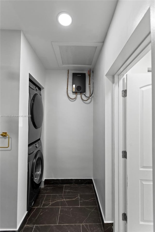 5233 NE 4th Ave, Oakland Park, FL 33334 - clothes washing area with marble finish floor, stacked washer and clothes dryer, baseboards, and laundry area