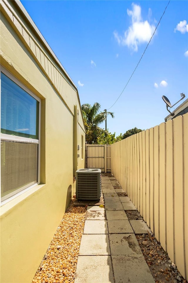 5233 NE 4th Ave, Oakland Park, FL 33334 - view of property exterior featuring stucco siding, fence, cooling unit, and a patio