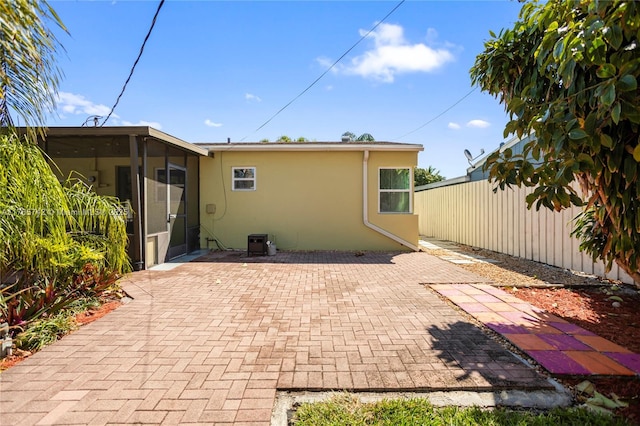 5233 NE 4th Ave, Oakland Park, FL 33334 - back of property featuring a patio area, stucco siding, a sunroom, and fence