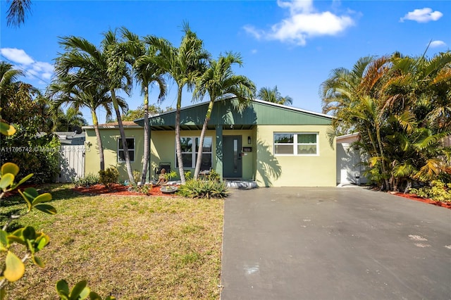 5233 NE 4th Ave, Oakland Park, FL 33334 - ranch-style house featuring a front yard, stucco siding, and fence