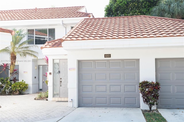 9203 NW 9th Ct, Plantation, FL 33324 - view of front of home with stucco siding, driveway, a tile roof, and a garage
