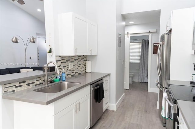 9203 NW 9th Ct, Plantation, FL 33324 - kitchen with backsplash, light wood-style floors, white cabinets, stainless steel appliances, and a sink