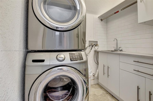 15852 SW 14th St, Pembroke Pines, FL 33027 - laundry area featuring stacked washer / drying machine, cabinet space, and a textured wall