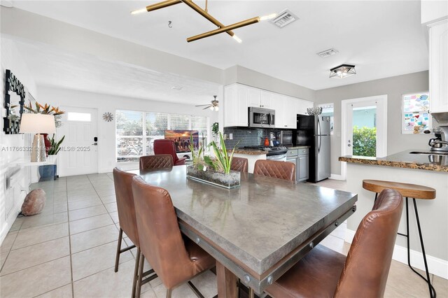 3449 NE 17th Way, Oakland Park, FL 33334 - dining space with plenty of natural light, light tile patterned floors, a ceiling fan, and baseboards