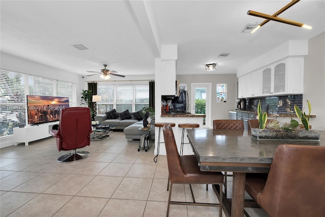 dining area with a ceiling fan, a wealth of natural light, visible vents, and light tile patterned floors