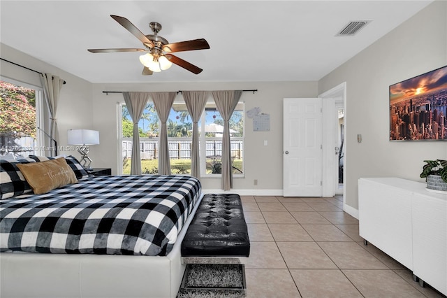 bedroom featuring light tile patterned floors, visible vents, baseboards, and a ceiling fan