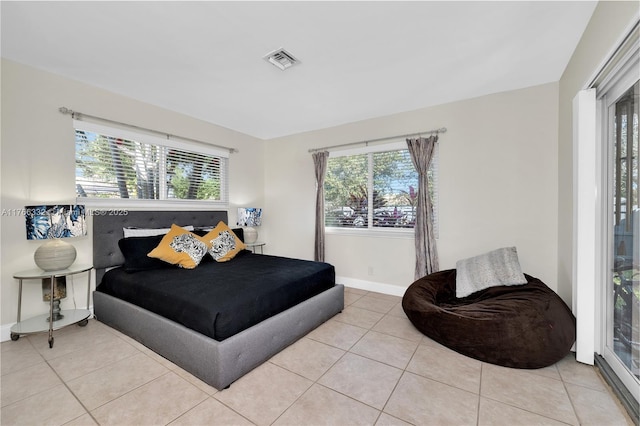 bedroom with tile patterned flooring, baseboards, visible vents, and multiple windows