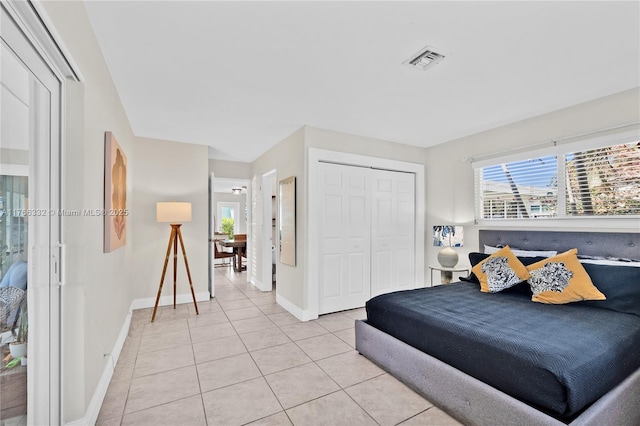 bedroom with light tile patterned floors, baseboards, a closet, and visible vents