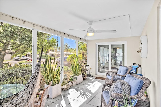 sunroom / solarium featuring tile patterned floors, a wealth of natural light, and a ceiling fan