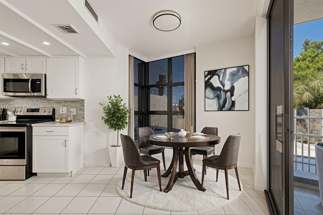 4000 Towerside Ter Unit 302, Miami, FL 33138 - dining area featuring floor to ceiling windows, healthy amount of natural light, light tile patterned floors, baseboards, and recessed lighting