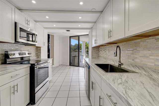 4000 Towerside Ter Unit 302, Miami, FL 33138 - kitchen with stainless steel appliances, a sink, backsplash, light tile patterned floors, and recessed lighting