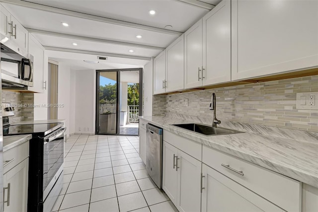 4000 Towerside Ter Unit 302, Miami, FL 33138 - kitchen featuring stainless steel appliances, a sink, backsplash, light tile patterned floors, and white cabinets