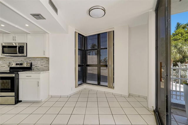 4000 Towerside Ter Unit 302, Miami, FL 33138 - kitchen featuring appliances with stainless steel finishes, tasteful backsplash, light countertops, white cabinets, and baseboards