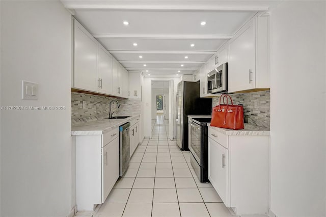 4000 Towerside Ter Unit 302, Miami, FL 33138 - kitchen with appliances with stainless steel finishes, a sink, backsplash, light tile patterned floors, and light countertops