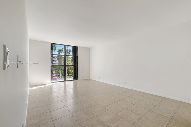 4000 Towerside Ter Unit 302, Miami, FL 33138 - empty room with light tile patterned floors, expansive windows, and baseboards