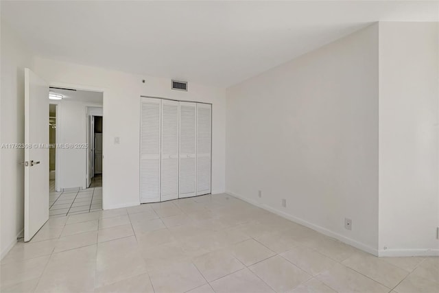4000 Towerside Ter Unit 302, Miami, FL 33138 - unfurnished bedroom with a closet, light tile patterned flooring, and baseboards
