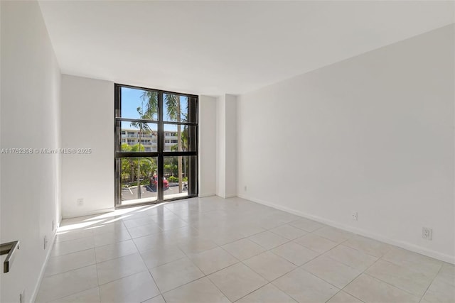 4000 Towerside Ter Unit 302, Miami, FL 33138 - spare room featuring expansive windows, light tile patterned floors, and baseboards