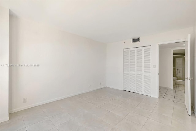 4000 Towerside Ter Unit 302, Miami, FL 33138 - unfurnished bedroom with light tile patterned floors, a closet, and baseboards