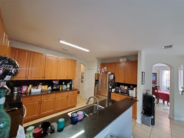 11009 NW 80th Ln, Doral, FL 33178 - kitchen featuring arched walkways, stainless steel fridge, light tile patterned floors, and brown cabinets