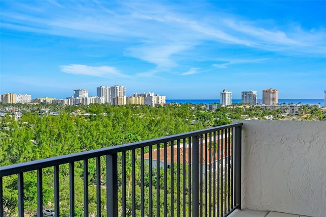 balcony featuring a water view and a city view