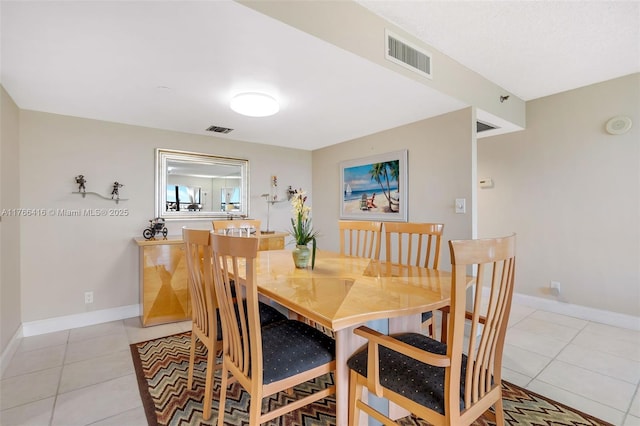 dining room featuring light tile patterned flooring, visible vents, and baseboards