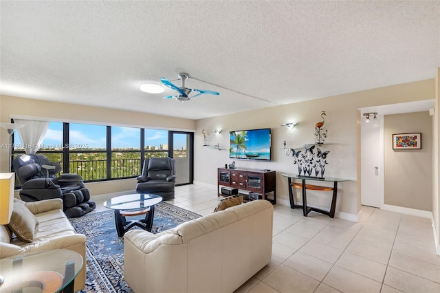 living room with light tile patterned flooring, baseboards, and a textured ceiling