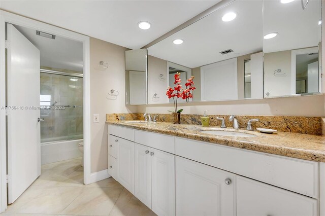 bathroom with double vanity, toilet, visible vents, and a sink
