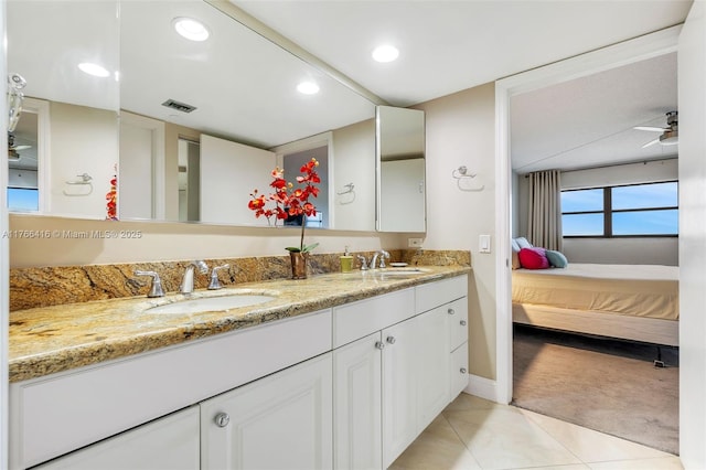 ensuite bathroom with tile patterned flooring, double vanity, visible vents, and a sink