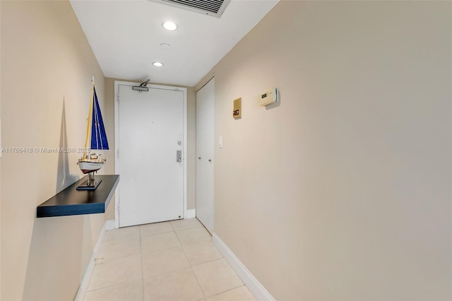 hallway featuring light tile patterned floors, visible vents, baseboards, and recessed lighting