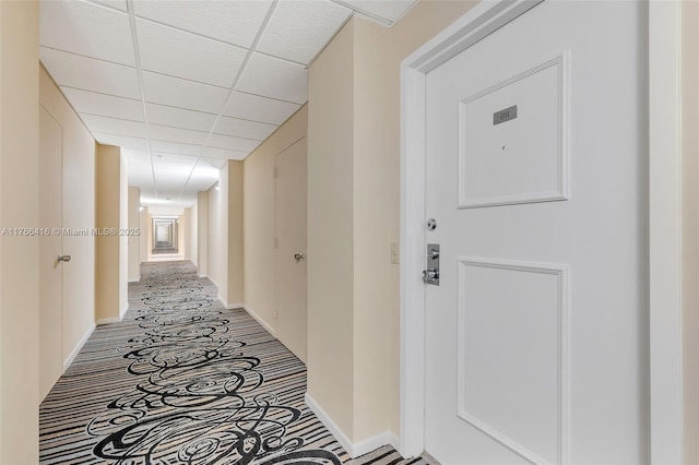corridor with a paneled ceiling